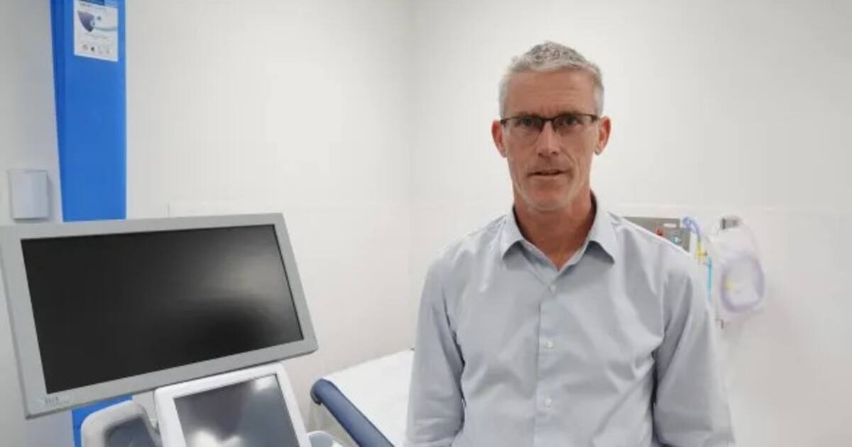 A gastroenterology specialist beside an endoscopy monitor in a clinic room, illustrating the loss of Palmerston North Hospital's last permanent gastroenterologist.